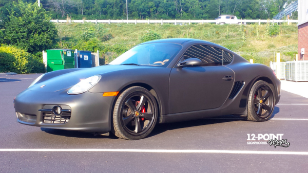 Full color change matte black wrap on a Porsche Cayman. 12-Point SignWorks.
