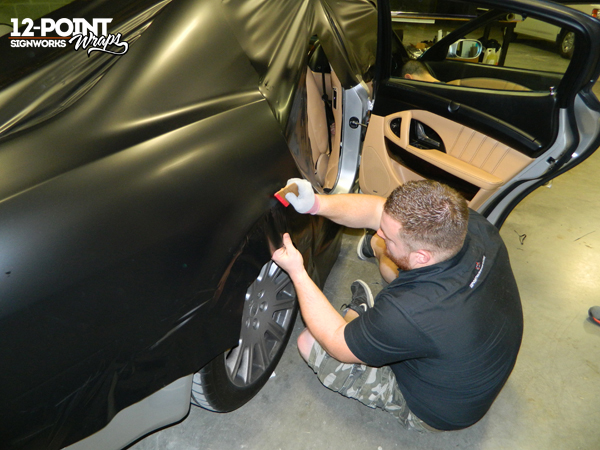 12-Point SignWorks employee wraps door jambs and wheel wells of Maserati