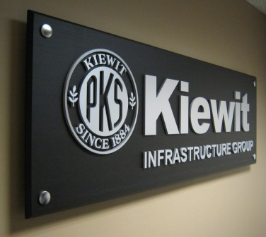 Dimensional letters and logo on sign panel with woodgrain architectural finish