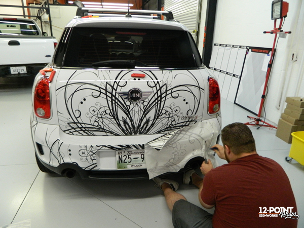 Rich using transfer tape to apply intricate cut vinyl graphics to a mini cooper. 12-Point SignWorks