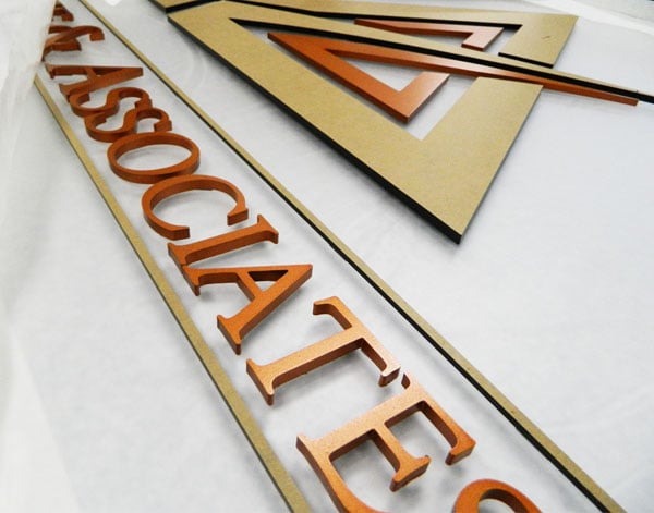 Close-up view of some of the dimensional logo sign for Acuff & Associates with the metallic copper paint. 12-Point SignWorks