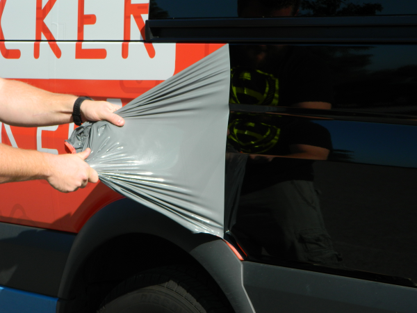 Peeling vinyl off of a bus