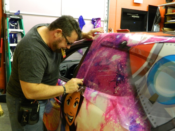 Mike putting perf on the back windows of the Janet's Planet vehicle wrap. 12-Point SignWorks.