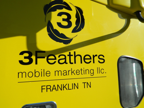 Vinyl logo and lettering on a trailer for 3 Feathers Mobile Marketing. 12-Point SignWorks