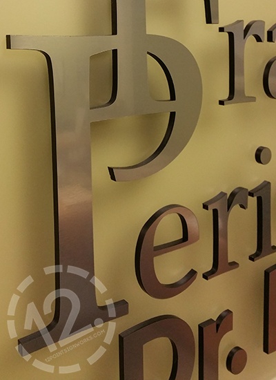 A close-up of the letters for the Franklin Periodontal sign, showing the black acrylic behind the brushed metal face. 12-Point SignWorks