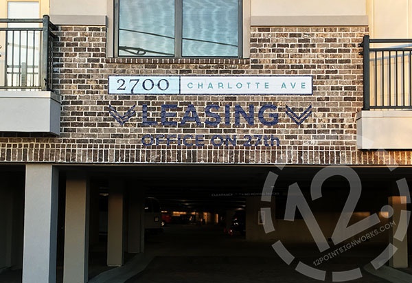 Custom vinyl directional signage applied on masonry for 2700 Charlotte Avenue Apartments in Nashville TN. 12-Point SignWorks - Franklin TN