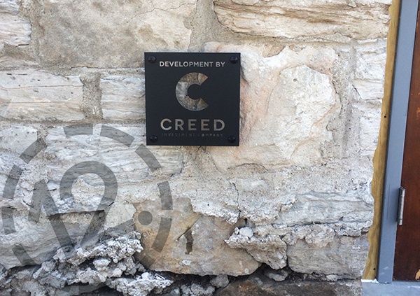 The Creed Investment Company exterior logo sign installed in stone in the Gulch in Nashville. 12-Point SignWorks - Franklin TN