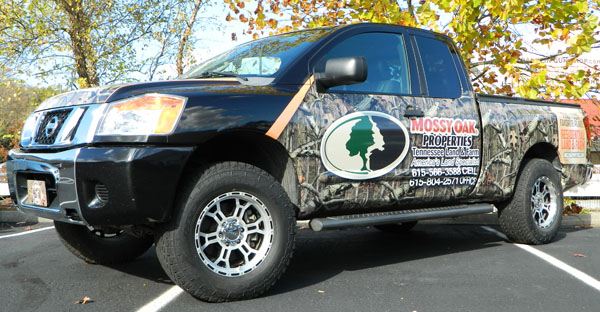 A custom advertising wrap on a Nissan Titan for Mossy Oak Properties. 12-Point SignWorks