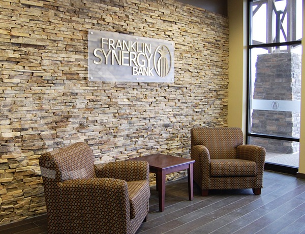 Custom logo sign on a stone wall for Franklin Synergy Bank in Spring Hill, TN. 12-Point SignWorks