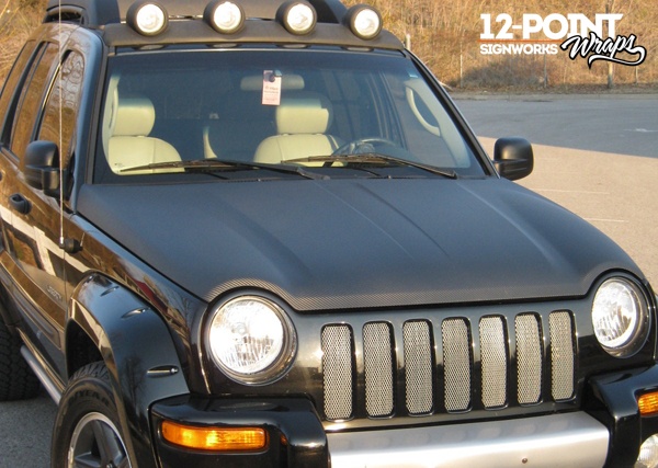 Black carbon fiber hood wrap on a Jeep installed by 12-Point SignWorks in Franklin, TN.