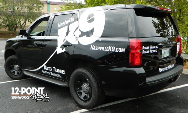 A view of the side and rear of the 2015 Chevy Tahoe, showing the custom vinyl graphics installed by 12-Point SignWorks.