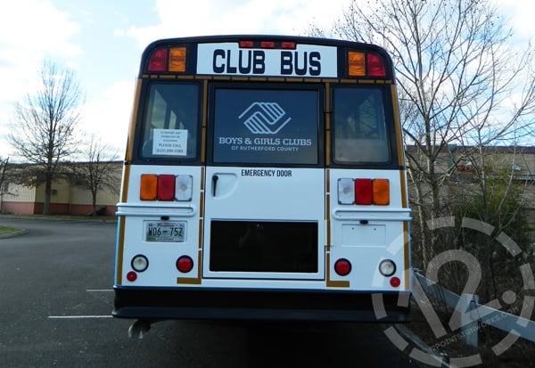 The completed rear of the bus, showing the white vinyl, cut decals, and perforated material for the rear window. 12-Point SignWorks
