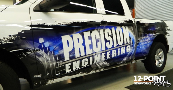 View of the side of the Precision Engineering truck with the partial advertising wrap. 12-Point SignWorks