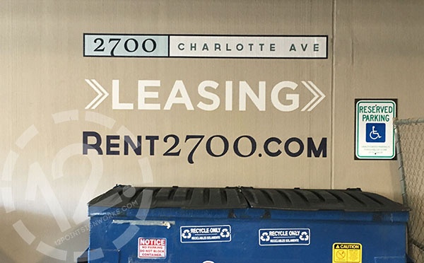 Custom vinyl directional signage applied on concrete wall for 2700 Charlotte Avenue Apartments in Nashville TN. 12-Point SignWorks - Franklin TN