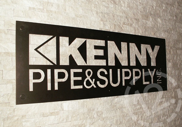 Logo sign in powder coated metal on a textured marble stone wall. 12-Point SignWorks