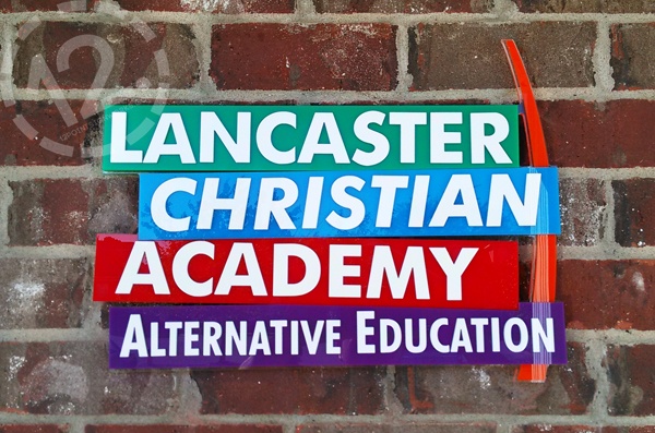 Lancaster Christian Academy Alternative Education signage installed on the brick exterior of the school. 12-Point SignWorks